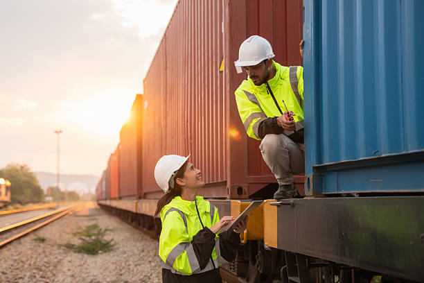 istock Foreman checking inventory or task details on freight train cars and shipping containers. Logistics concept, import, and export industries. 2229191655
