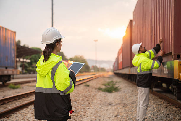 istock Foreman checking inventory or task details on freight train cars and shipping containers. Logistics concept, import, and export industries. 2229191691