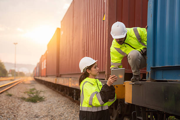 istock Foreman checking inventory or task details on freight train cars and shipping containers. Logistics concept, import, and export industries. 2229191705