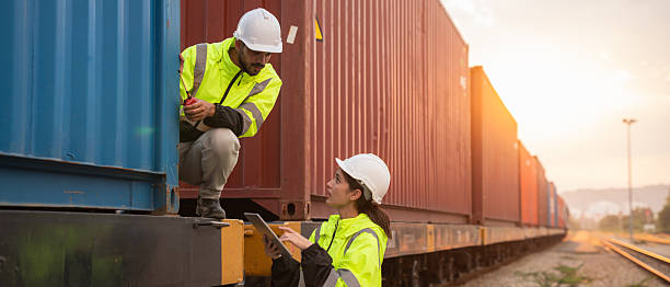 istock Foreman checking inventory or task details on freight train cars and shipping containers. Logistics concept, import, and export industries. 2229191736