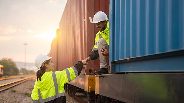 istock Foreman checking inventory or task details on freight train cars and shipping containers. Logistics concept, import, and export industries. 2229191955