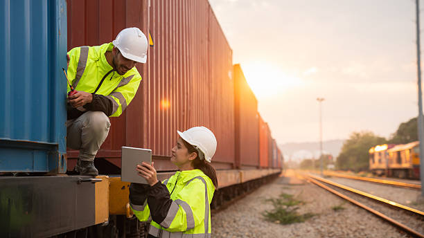 istock Foreman checking inventory or task details on freight train cars and shipping containers. Logistics concept, import, and export industries. 2229192081