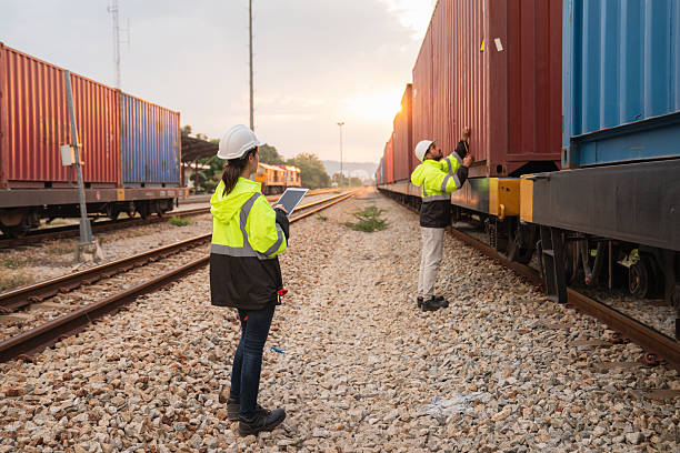 istock Foreman checking inventory or task details on freight train cars and shipping containers. Logistics concept, import, and export industries. 2229192129