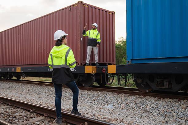 istock Foreman checking inventory or task details on freight train cars and shipping containers. Logistics concept, import, and export industries. 2229192202