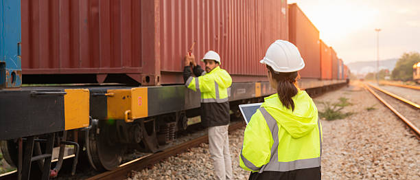 istock Foreman checking inventory or task details on freight train cars and shipping containers. Logistics concept, import, and export industries. 2229192305