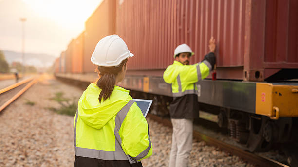 istock Foreman checking inventory or task details on freight train cars and shipping containers. Logistics concept, import, and export industries. 2229192374