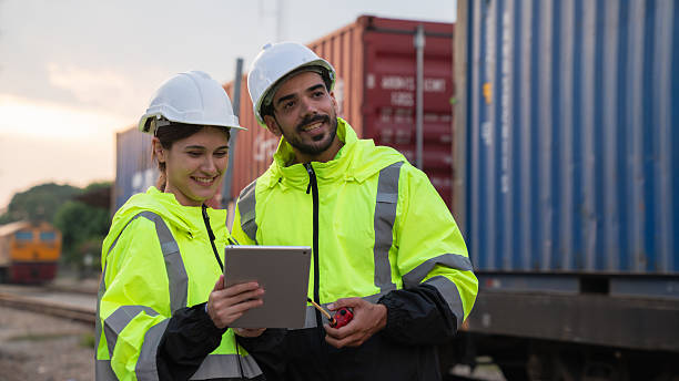 istock Foreman checking inventory or task details on freight train cars and shipping containers. Logistics concept, import, and export industries. 2229192407