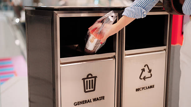 istock Throwing the trash into the bin to keep the area clean and tidy 2229192962