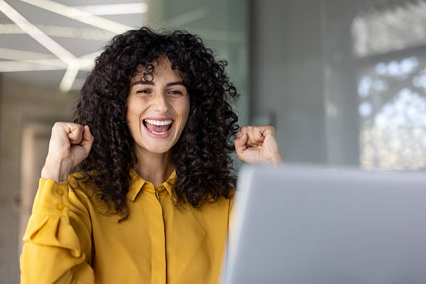 istock Happy woman exclaims with joy while looking at her laptop, celebrating a victory. 2229195534