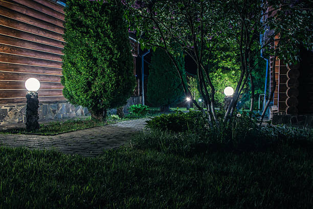 istock A beautifully illuminated brick walkway lined with trees on both sides at night 2229196333