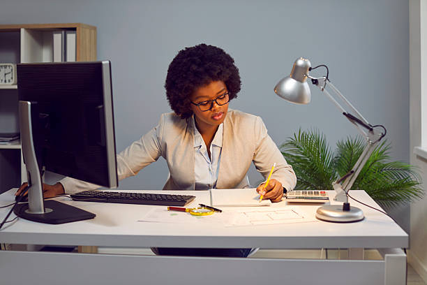 istock Focused businesswoman making notes on paper while working on laptop 2229200011