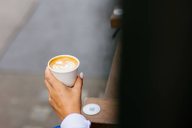 Woman holding coffee to go