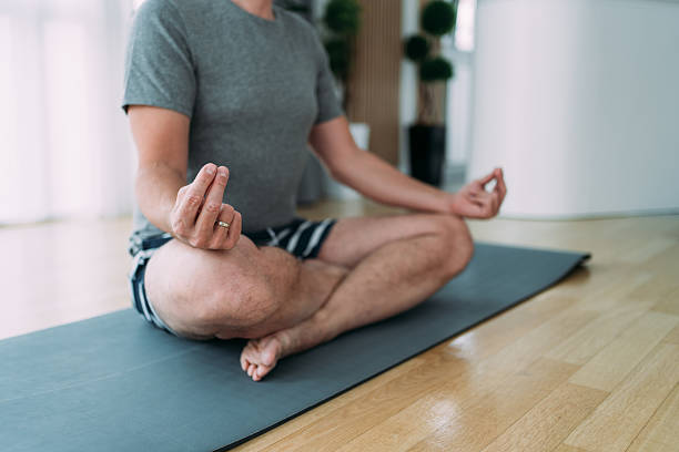 istock Man meditating in Lotus position at home. 2229200408
