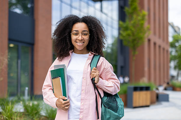 istock Joyful African American student poses on campus with books and backpack. 2229202696