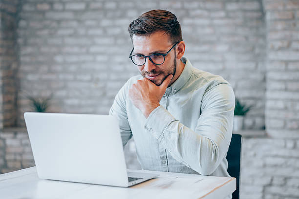istock Successful businessman in modern office working on laptop. 2229203973