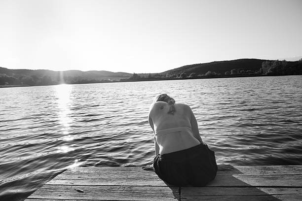 Una donna fatta in un momento di relax e pensieri vicino ad un lago nella tranquillità