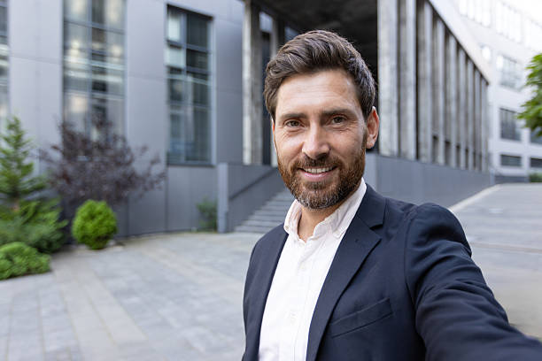 istock A successful businessman in a suit smiles warmly at the camera while making a video call. 2229206652