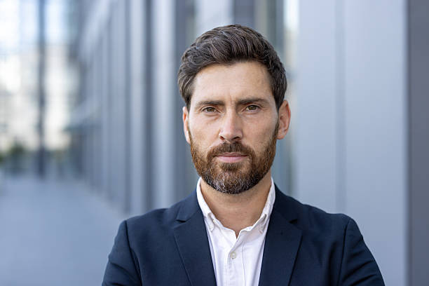 istock A professional businessman in a suit with a serious expression looks directly at the camera. 2229206703