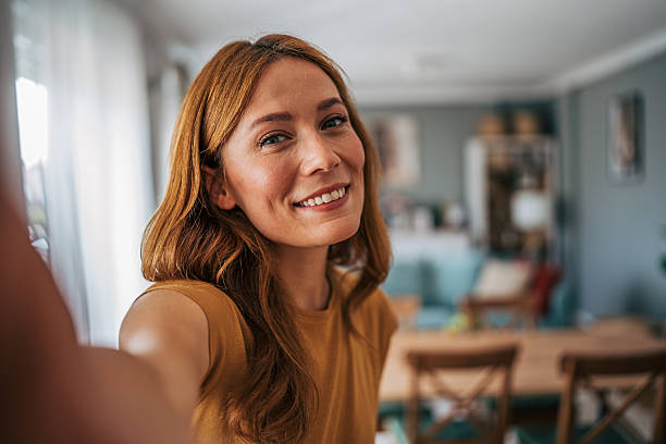 istock Young woman taking a selfie at home smiling at the camera 2229207592