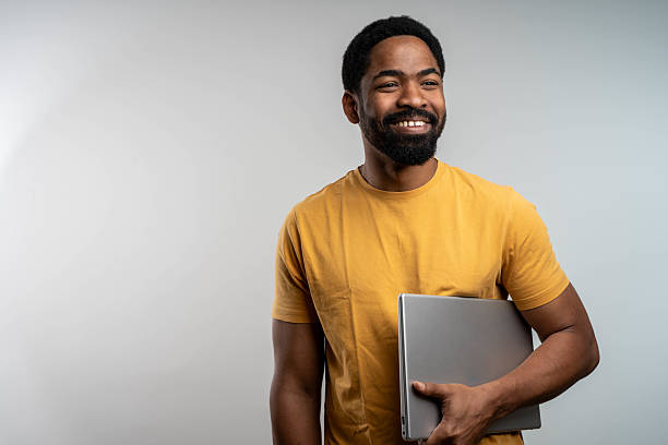 istock Happy black man holding closed laptop isolated on white background, freelance remote worker concept 2229208287