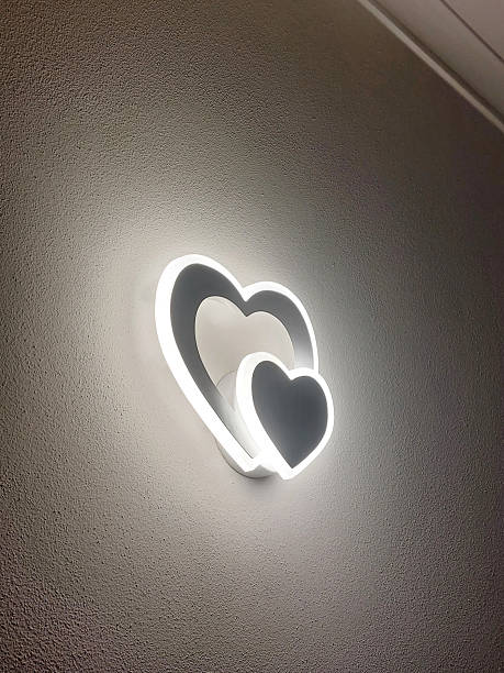Heart-shaped led wall light illuminating a textured wall