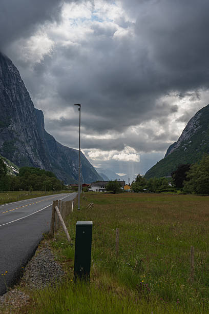 istock Rural Road with Mountain Cliffs and Cloudy Sky in Lysebotn, Norway 2229210824