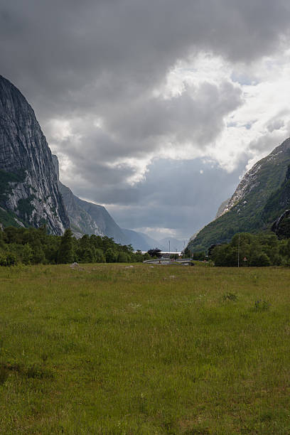 istock Towering Cliffs and Lush Valley in Lysebotn, Norway Under Cloudy Sky 2229211736