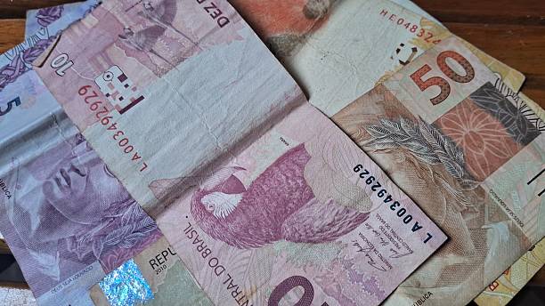 istock Brazilian real notes superimposed on a wooden background 2229213017