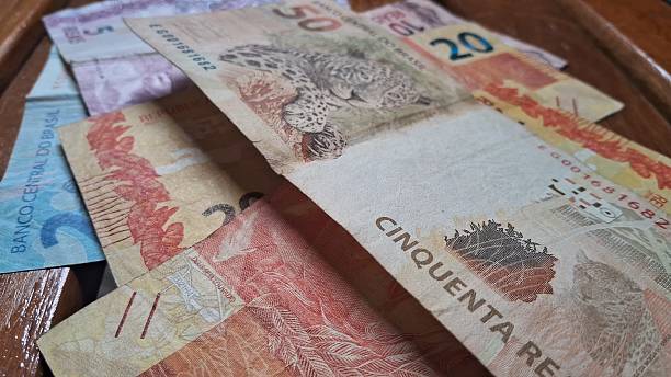 istock Brazilian real notes superimposed on a wooden background 2229213091