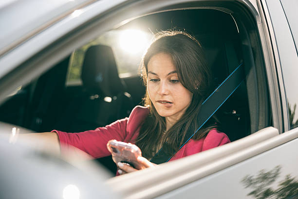 istock Woman Driving And Looking At Phone 2229214988