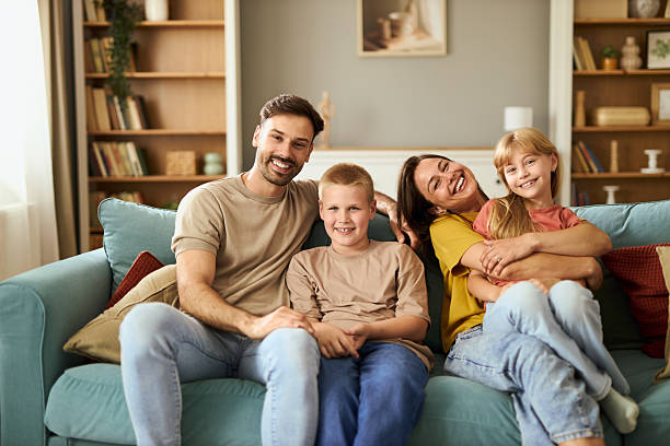 istock Smiling family enjoying on sofa at home. 2229217460
