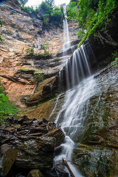 istock A stunning multi-tiered waterfall cascading down rocky cliffs surrounded by lush greenery. 2229217915