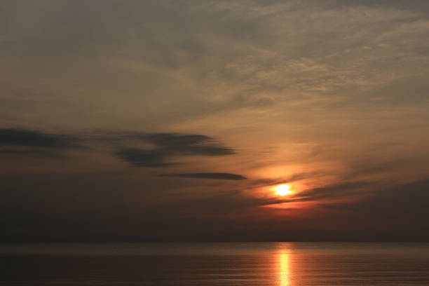 Sunrise over the sea, morning clouds, golden sea from the light of the rising sun.
