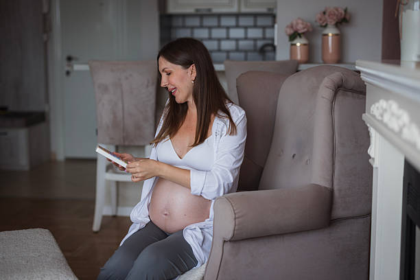Pregnant woman sitting on an armchair and taking vitamins