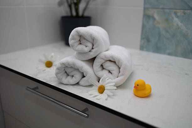 istock Towels Neatly Arranged With Daisies and a Rubber Duck in a Relaxing Bathroom Setting 2229226937