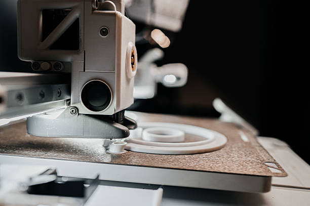 istock 3D printer close up. A working 3D printer in process of printing object from molten plastic. 3D printer creating model by flowing liquid plastic from an extruder of printer. 3D printing technology 2229229403