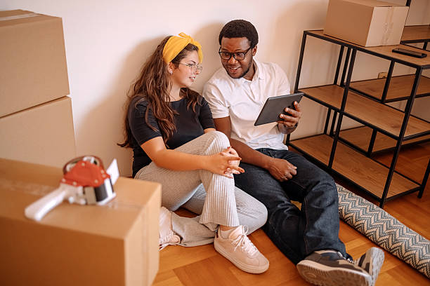 istock People moving in new apartment and using wireless technology while sitting on living room floor close to wall 2229229977