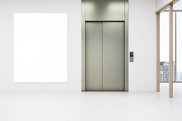 istock Vertical blank poster mockup next to modern elevator doors in a bright, clean office building hallway interior with large windows and city view. 3D Rendering 2229232840
