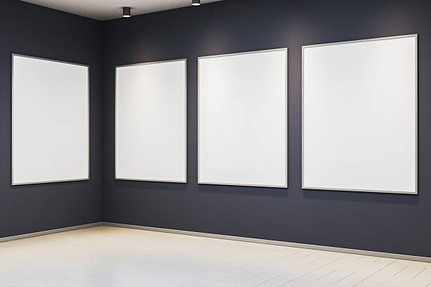 istock Contemporary gallery interior with four blank vertical poster frames on dark walls in corner display under spotlights for artwork or exhibition mockup. 3D Rendering 2229232913