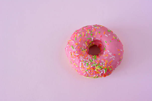 istock Pink Frosted Donut with Colorful Sprinkles copy space 2229235373