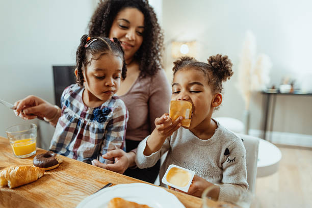 Family with two little daughters enjoying breakfast together