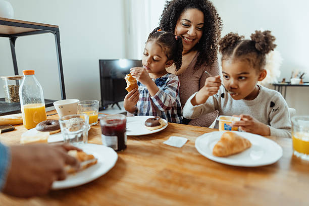 istock Family with two little daughters enjoying breakfast together 2229237404
