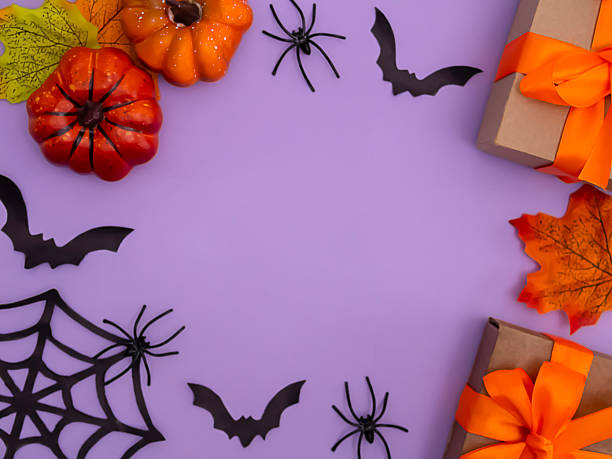 istock Halloween holiday decorations including gift box, pumpkins, spiders, bats on purple background 2229238026