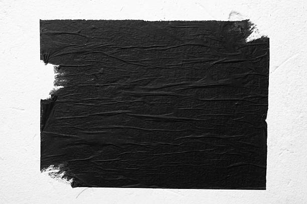 istock A black torn poster is taped to a white wall. 2229238320