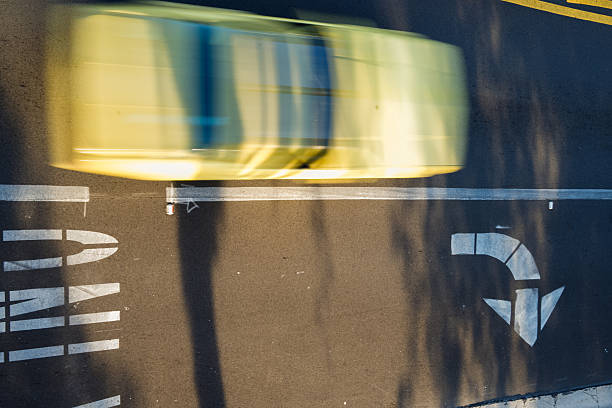 Overhead shot of a blurred yellow car passes a turn only lane