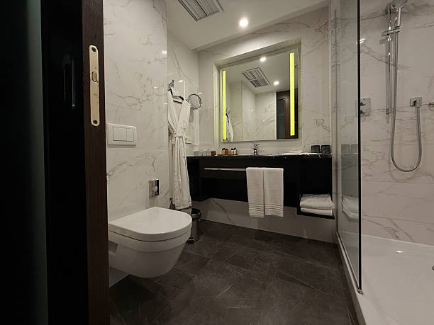 istock Minimalist bathroom interior in hotel featuring shower, toilet, and sink. Concise modern bathroom design concept. Handheld mobile photo, selective focus, non AI 2229248613