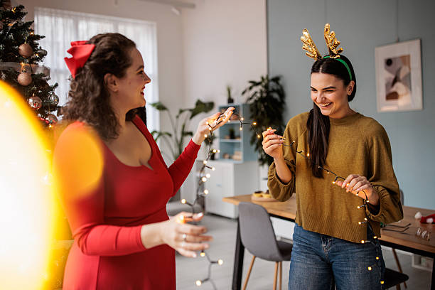 istock Women Decorating with String Lights on New Year’s Day 2229249526