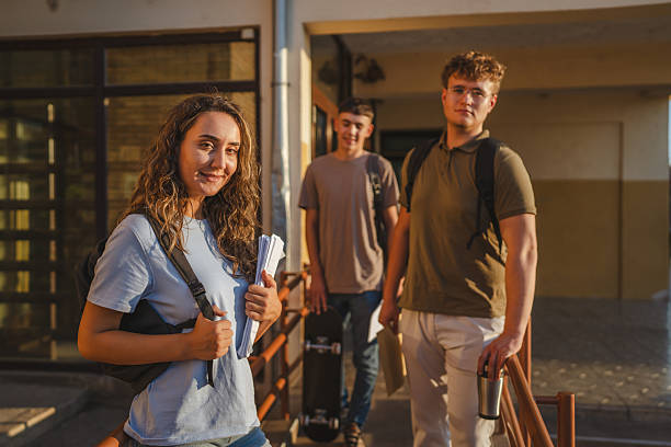 istock Students leaving school at sunset holding backpacks and skateboard 2229252504