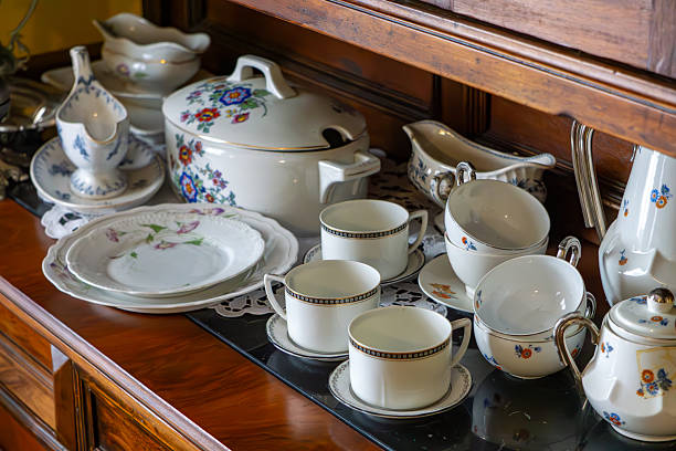 istock Antique porcelain tableware set with floral patterns, arranged on a wooden sideboard with a lace doily. 2229262961