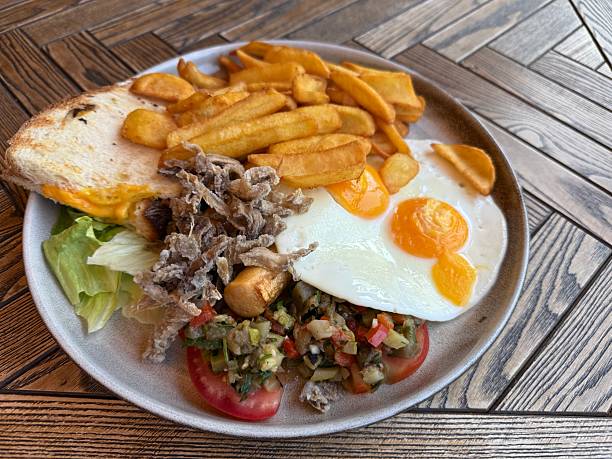 istock Breakfast plate with sunny side eggs, fries, toast, and salad 2229263709